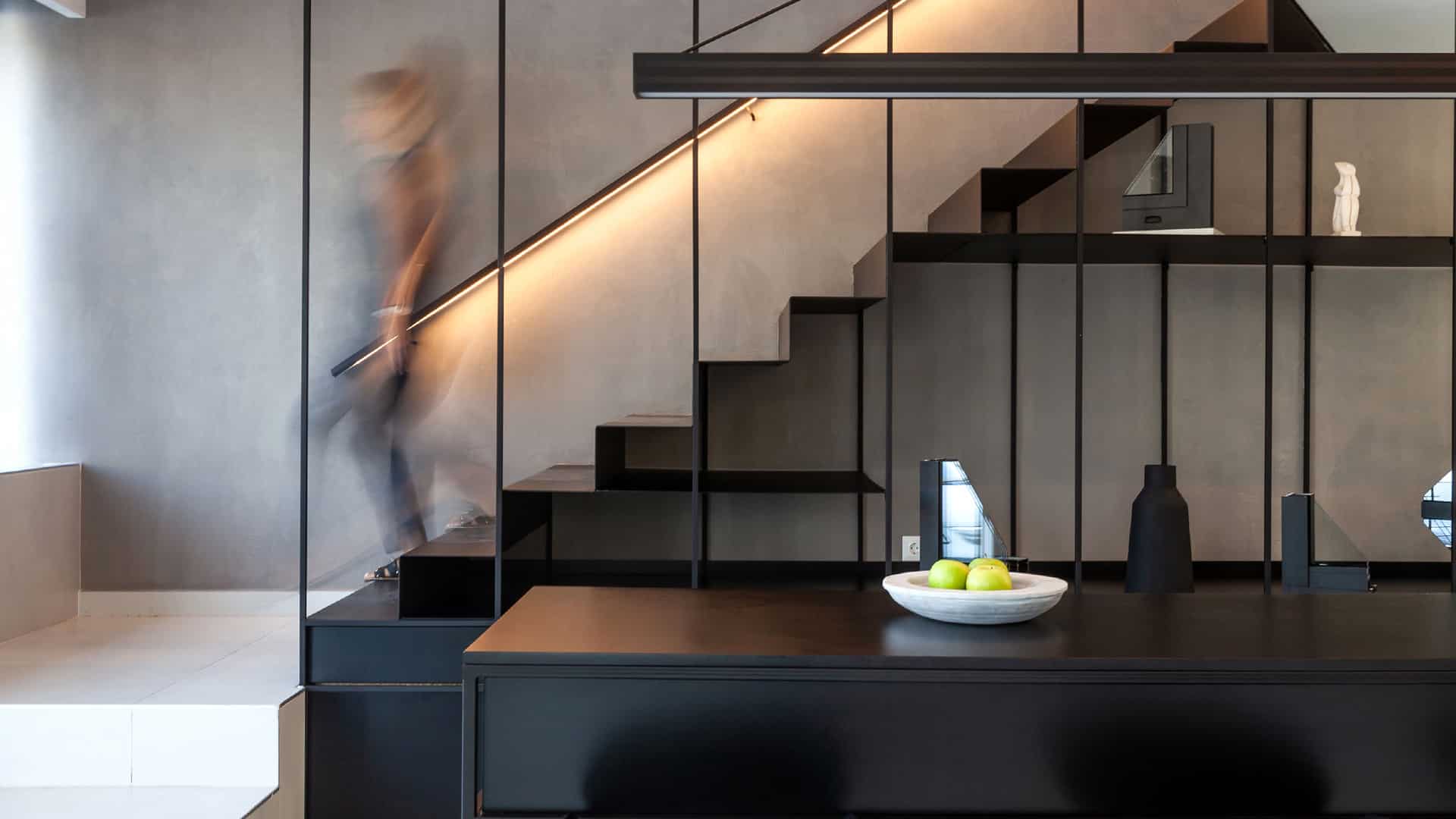 an interior staircase with a female figure descending